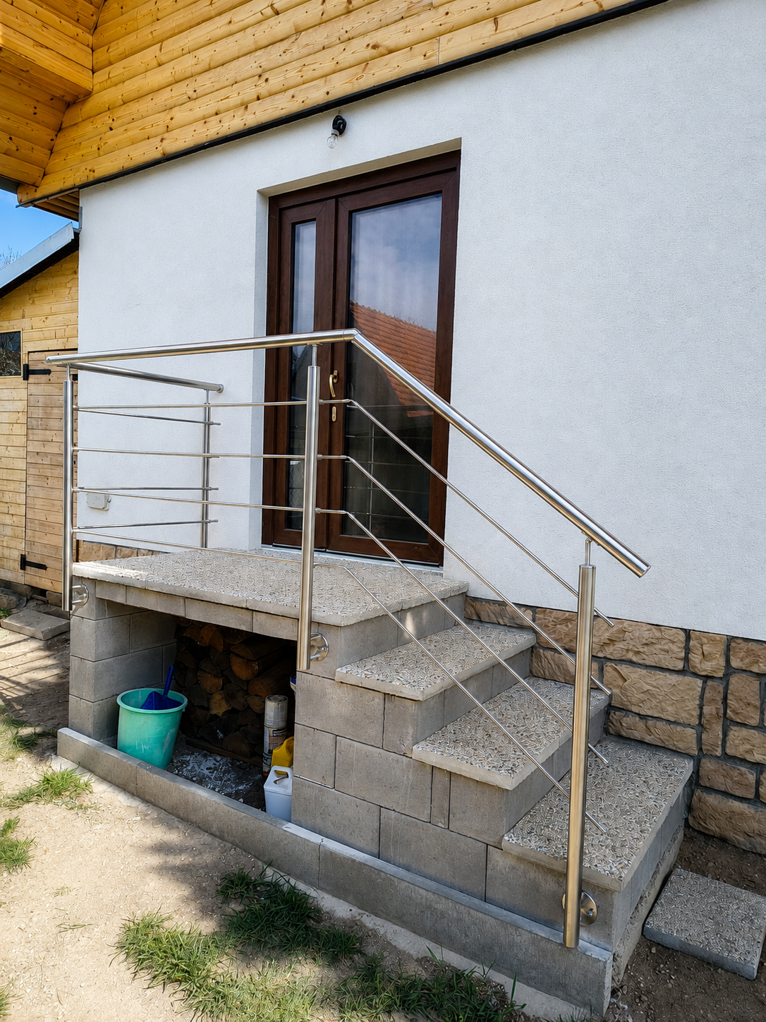 Nerezové zábradlí u vstupních schodů do domu s vodorovnými pruty